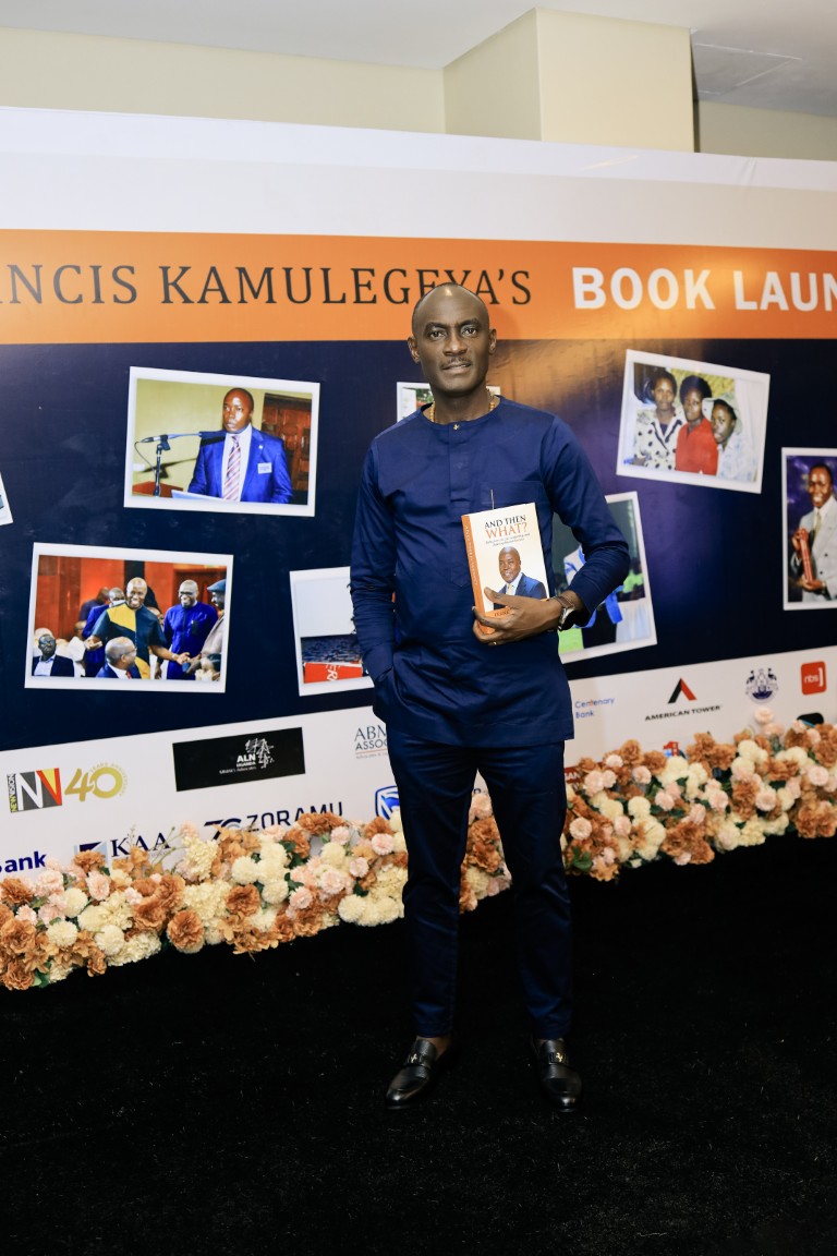 Joe Bali holding And Then What? at Francis Kamulegeya's book launch